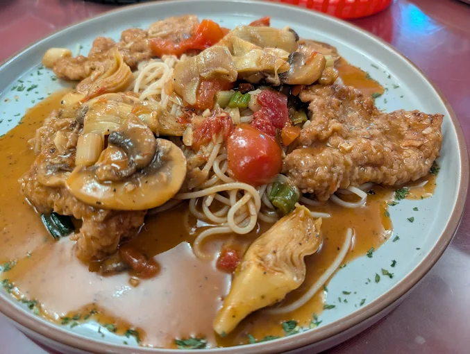 Chicken sauteed with mushrooms over pasta